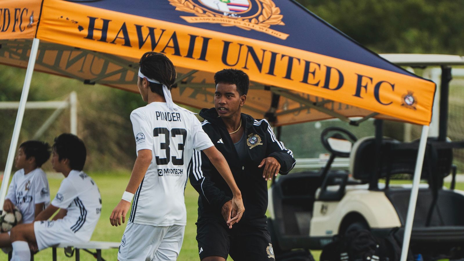 Coach Joe on the sideline giving a player instructions during a club game